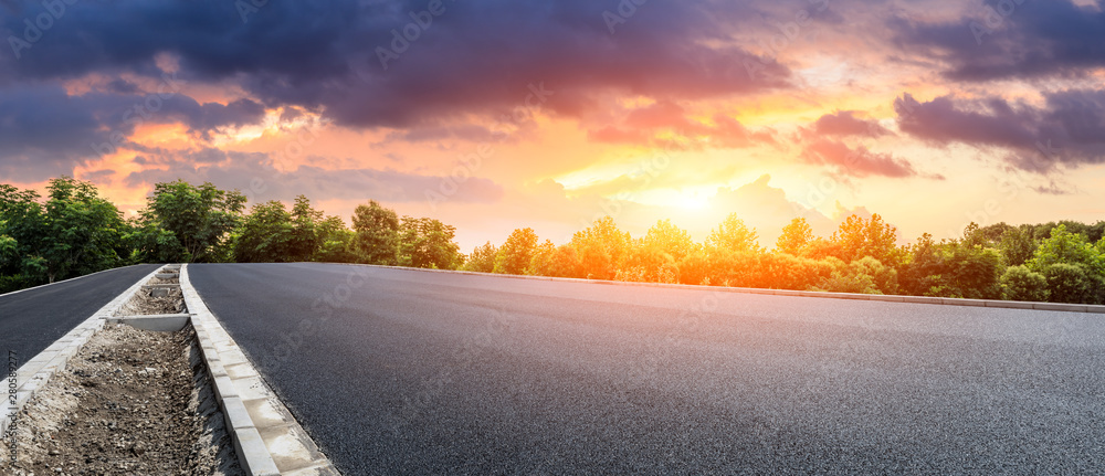 日落时分，沥青公路和绿色森林与美丽的云雾景观