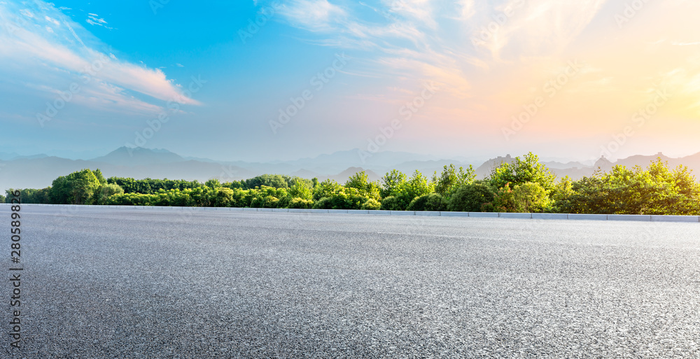 日落时分，沥青公路和绿色森林与美丽的云层景观