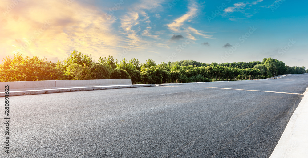 Asphalt highway and green forest with beautiful cloud landscape at sunset