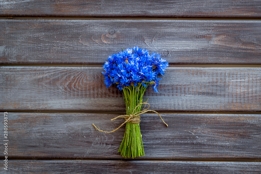 Field flowers design with bouquet of blue cornflowers on wooden background top view space for text