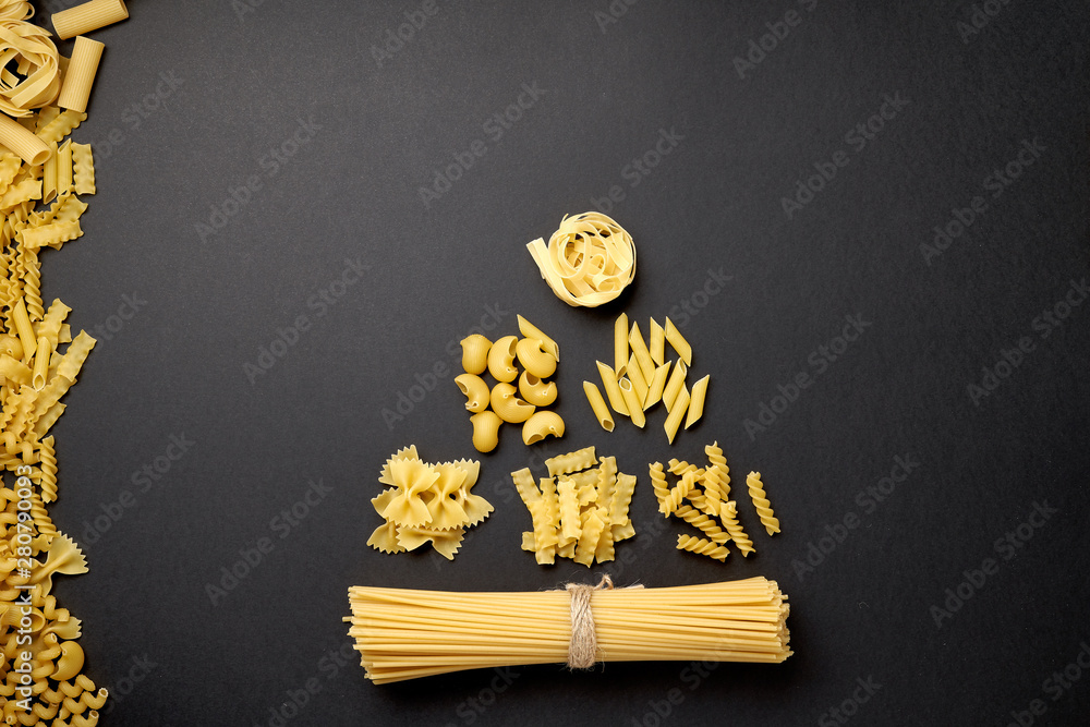 A christmas tree made with various forms of pasta on black background. Top view. Copy space for text