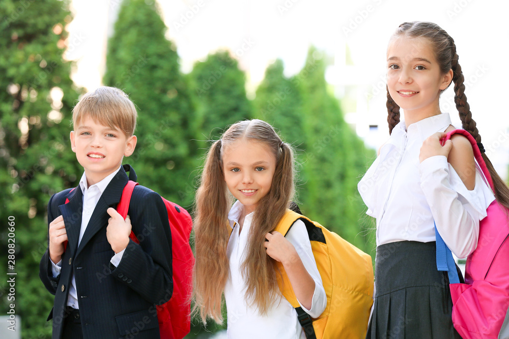 Cute little pupils after classes outdoors