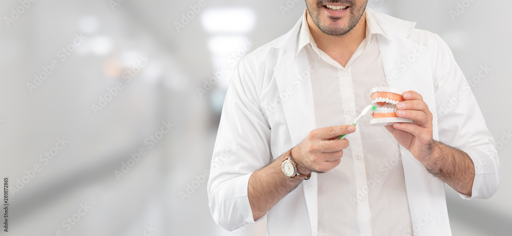 Young male dentist working in dental clinic. Dentistry care and medical service concept.