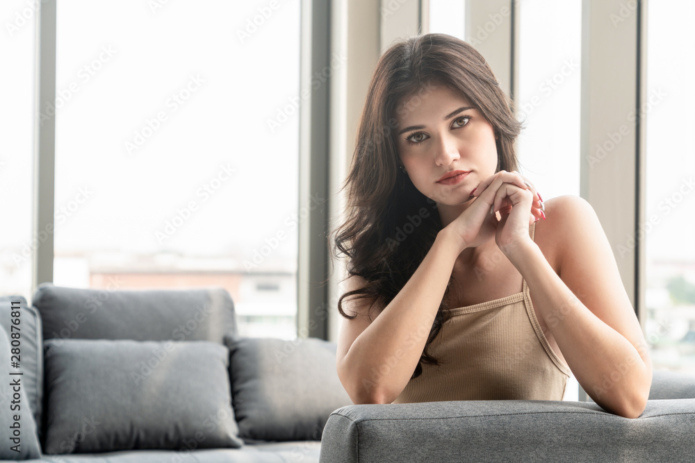 Beautiful relaxed business woman sitting on sofa couch in highrise office building tower.