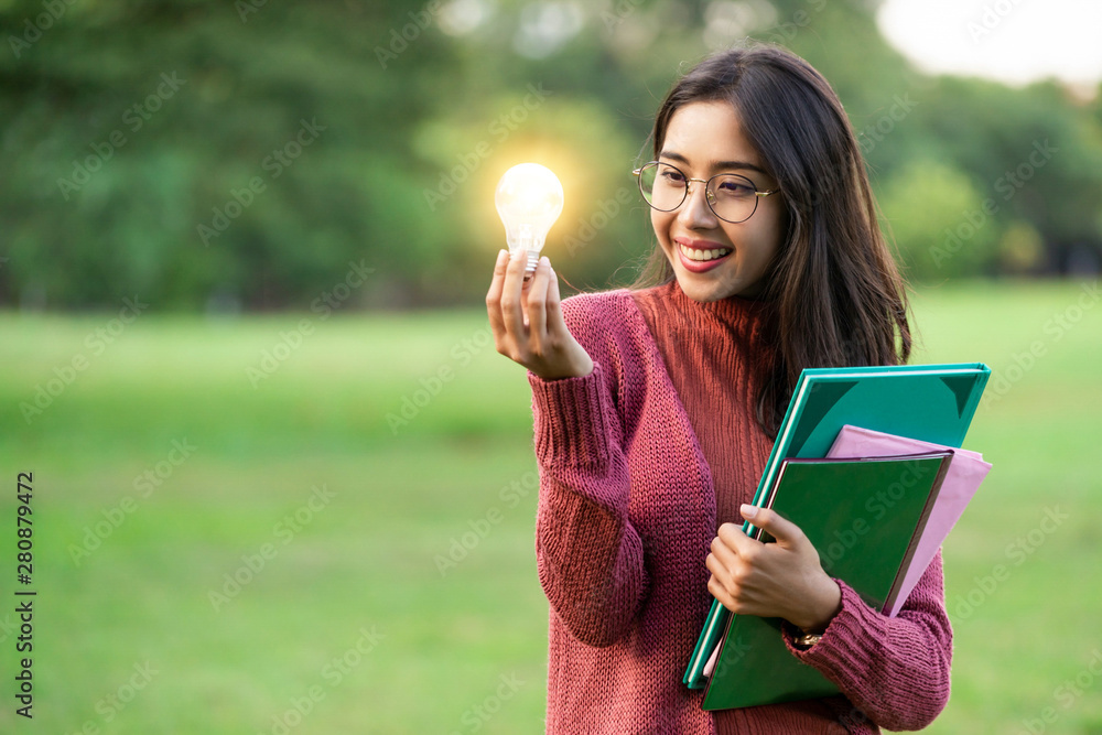 Creative young woman hold shinning light bulb. Concept of knowledge, intelligence and inspiration.