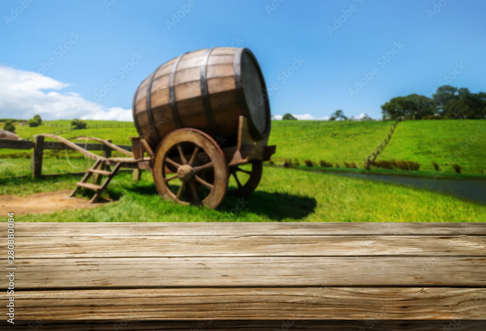 Brown wood table in green spring vineyard landscape with empty copy space on the table for product d