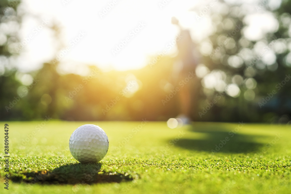 golf player putting golf ball into hole