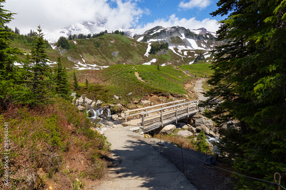 Beautiful view of a trail and a bridge over the river surrounded by the Mountain Landscape during a 