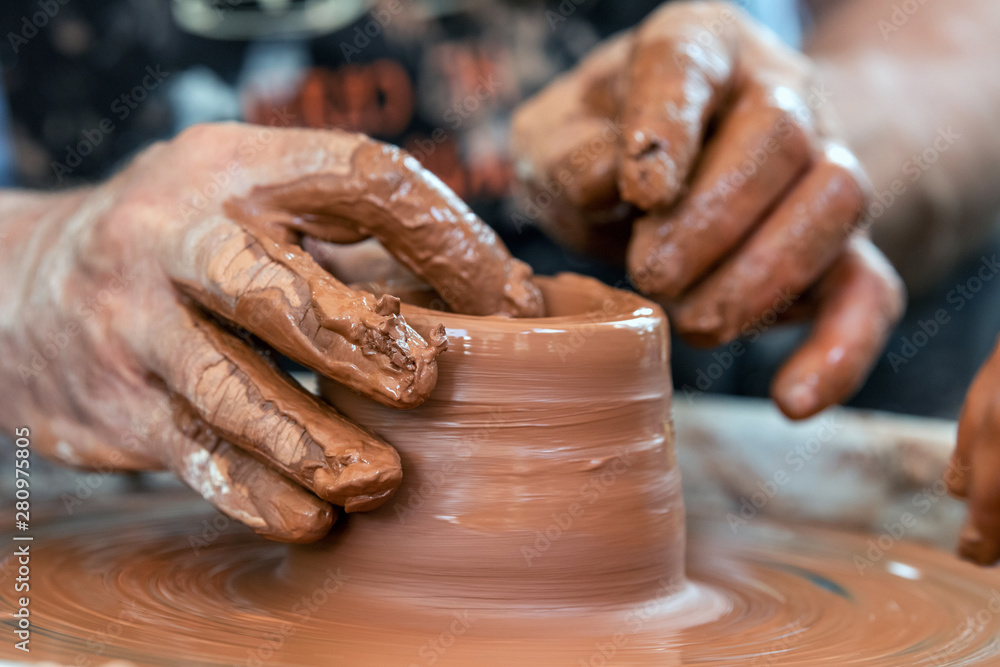 Potter makes pottery dishes on potters wheel