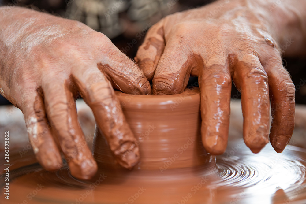 Potter makes pottery dishes on potters wheel