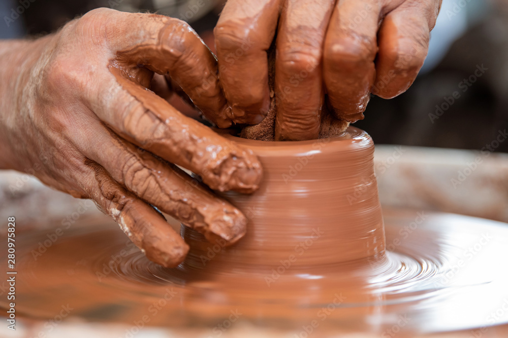 Potter makes pottery dishes on potters wheel