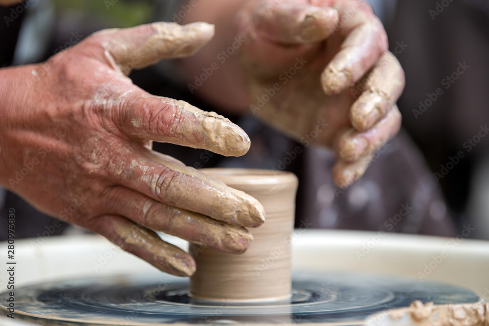 Potter makes pottery dishes on potters wheel