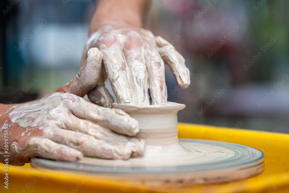 Potter makes pottery dishes on potters wheel