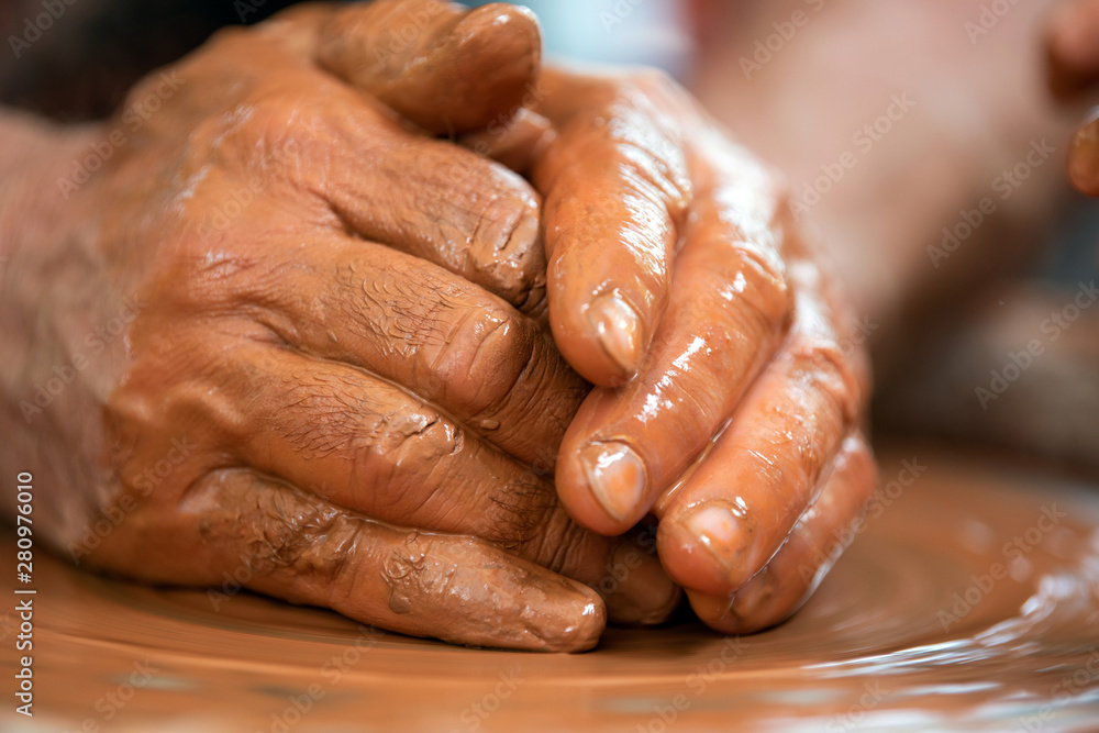 Potter makes pottery dishes on potters wheel