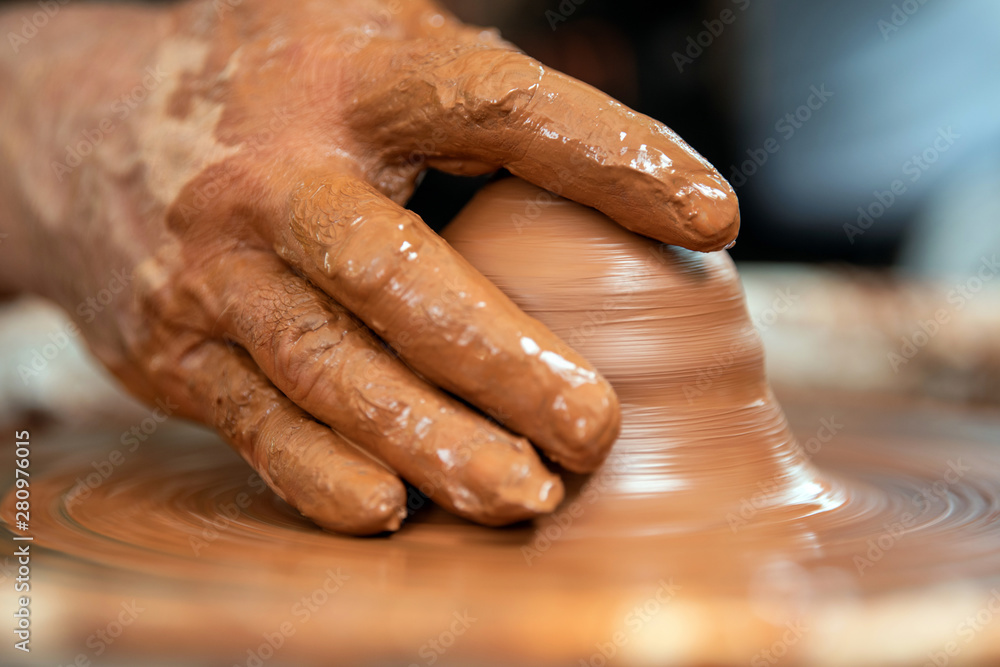 Potter makes pottery dishes on potters wheel