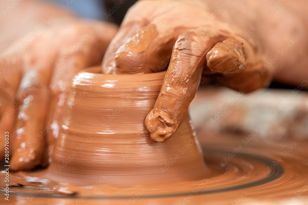 Potter makes pottery dishes on potters wheel