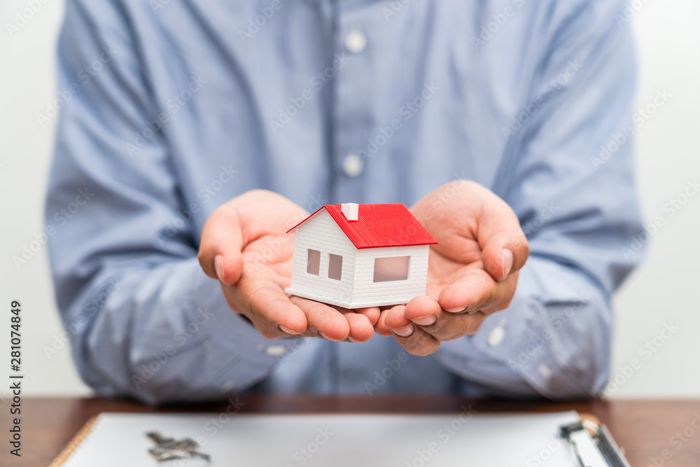 Real estate agent holding house model - real estate sales concept picture