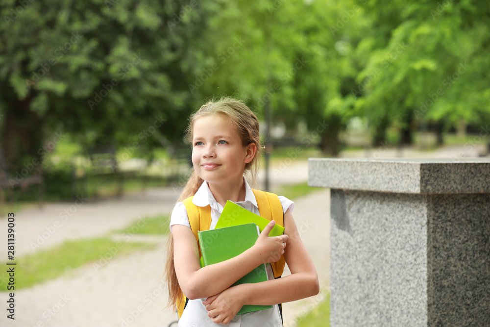 Cute little schoolgirl in park