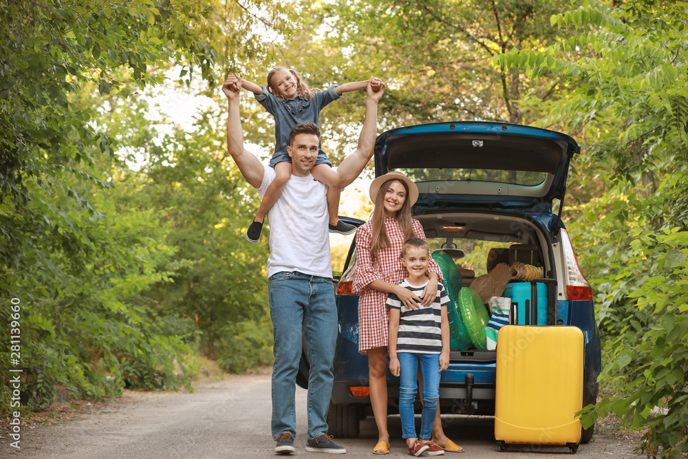 Happy family near car with luggage outdoors