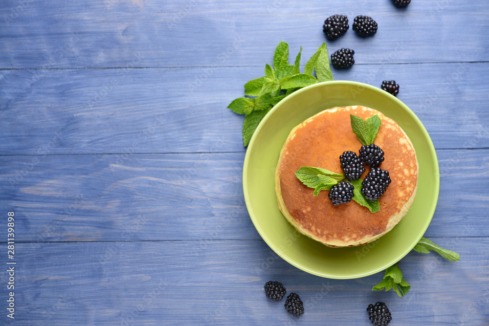 Tasty pancakes with blackberry on wooden table