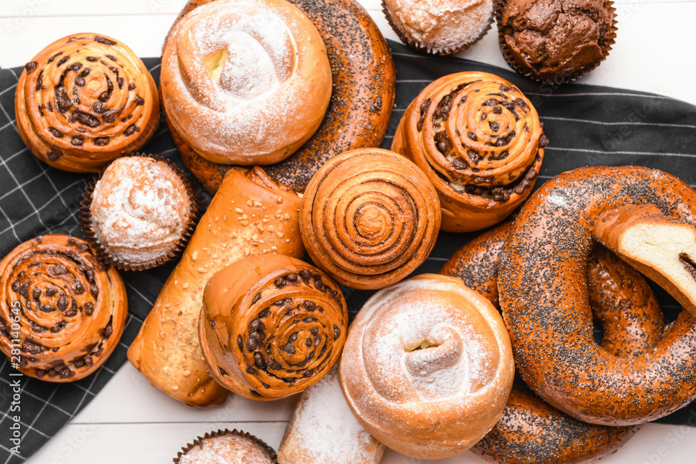 Heap of tasty pastries on white wooden background