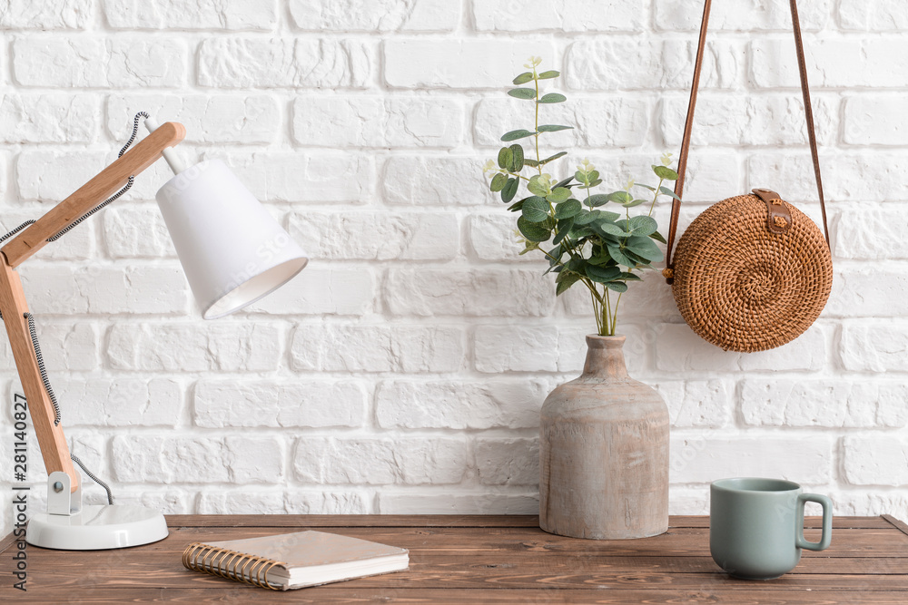 Stylish workplace near white wall in room