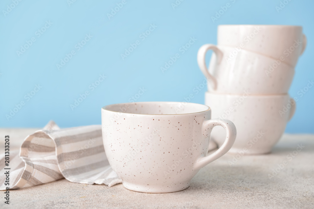 Ceramic cup on light table against color background