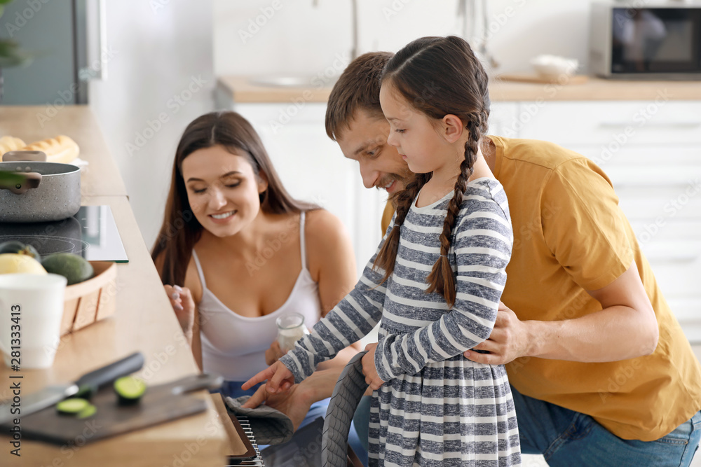 Young family with freshly baked buns in kitchen