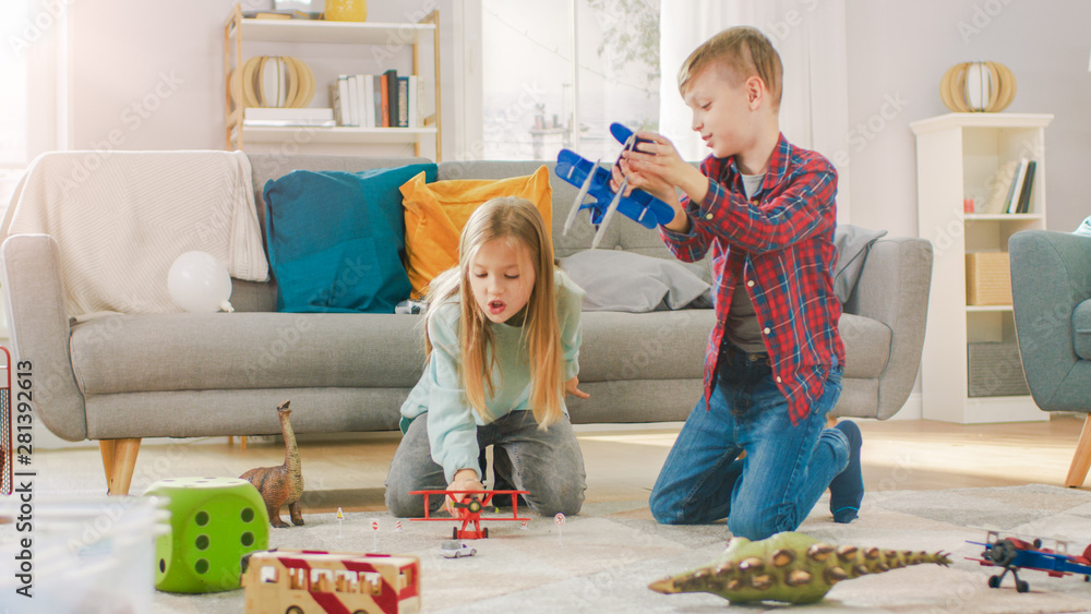 In the Living Room: Boy and Girl Playing with Toy Airplanes and Dinosaurs while Sitting on a Carpet.