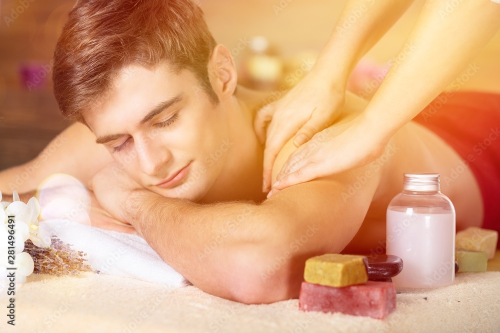 Young man having massage in spa salon