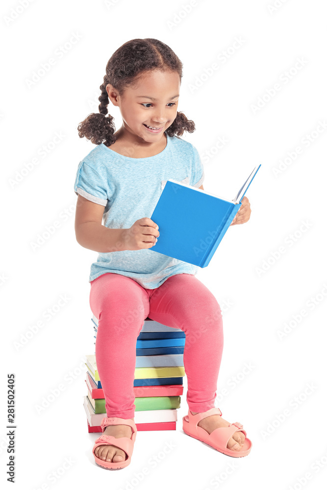 Adorable little African-American schoolgirl reading book on white background