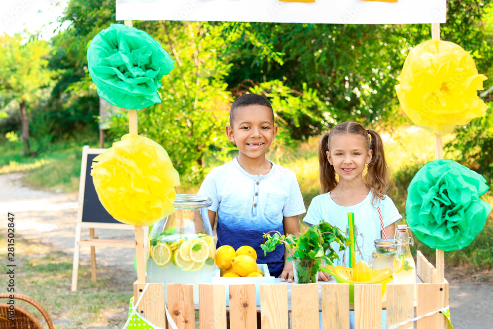 Cute little children at lemonade stand in park