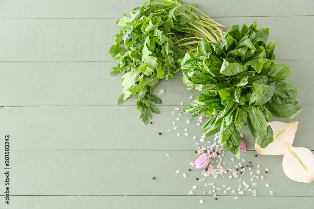 Different fresh herbs with vegetables and spices on wooden table