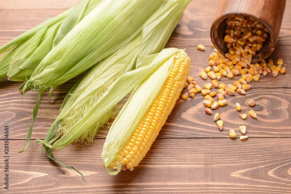 Fresh corn cobs on wooden background