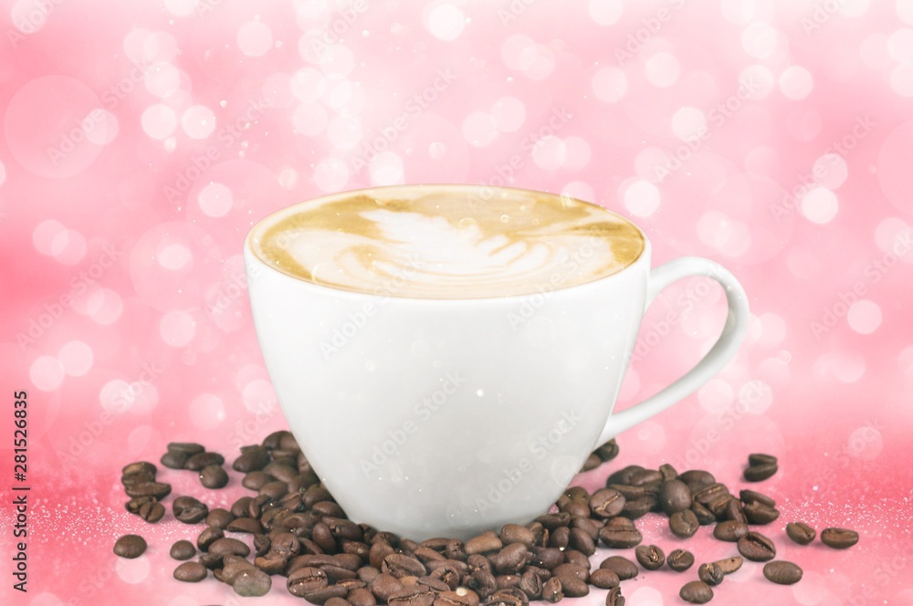 A cup of coffee with beans on pink background