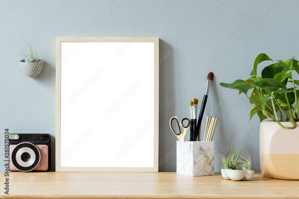 Stylish home interior with mock up photo frame on the brown wooden table with office accesories, ins