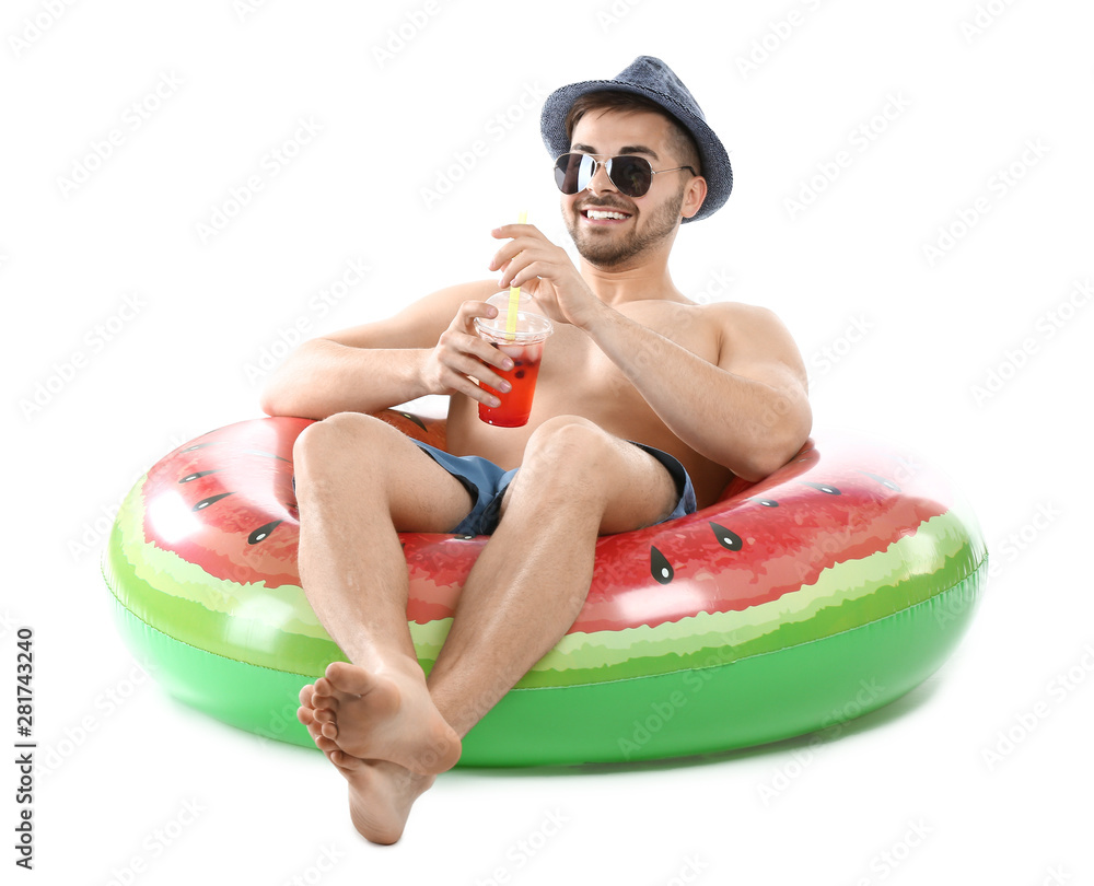 Happy young man with inflatable ring and cocktail on white background