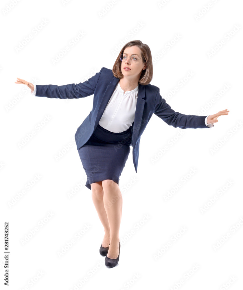 Balancing young businesswoman on white background