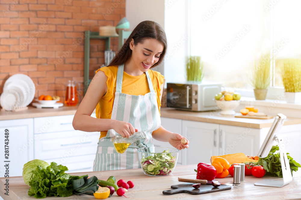 漂亮女人在家厨房准备美味的蔬菜沙拉