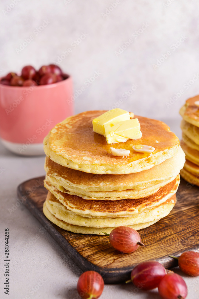 Tasty pancakes with butter and gooseberry on table