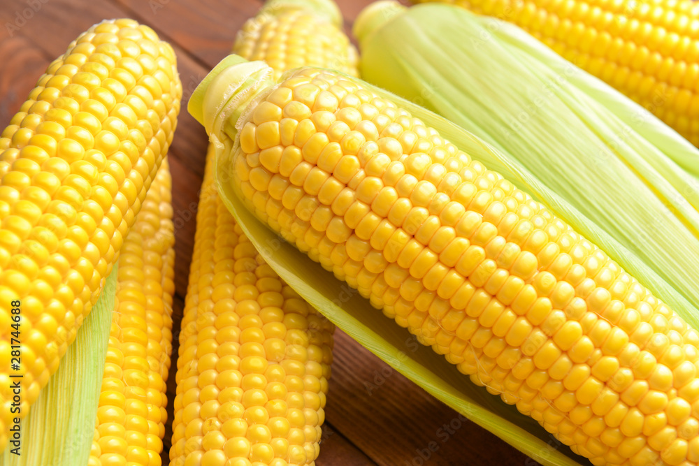 Fresh corn cobs on wooden background, closeup