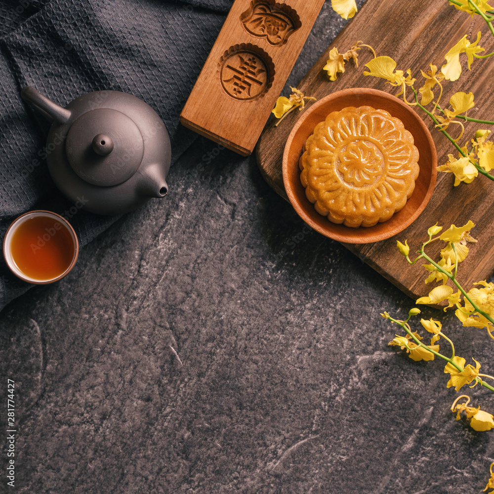 中秋节传统美食理念-黑石板桌上的漂亮月饼配茶，啪