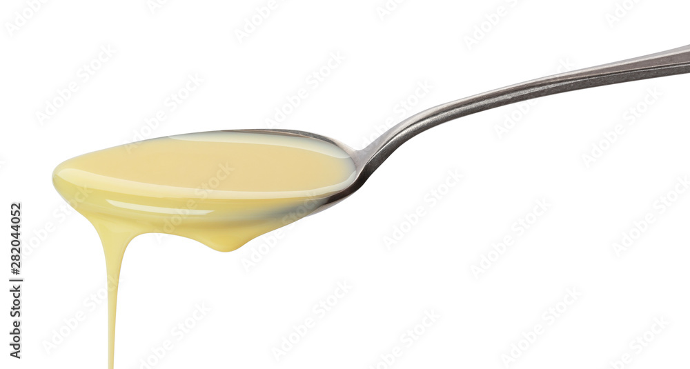 Pouring condensed milk isolated on white background