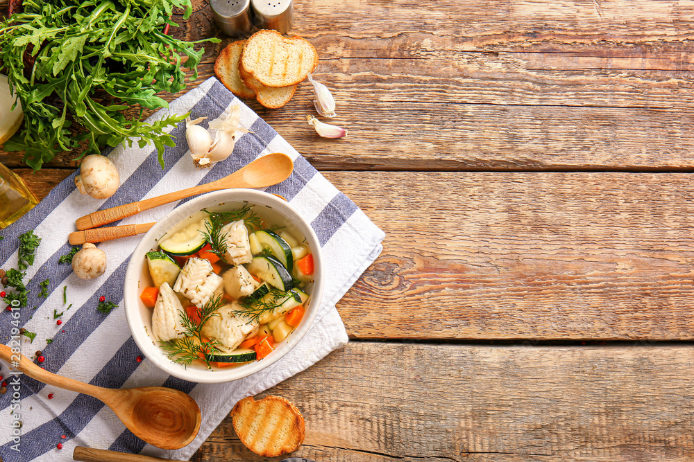 Bowl of tasty soup on wooden table