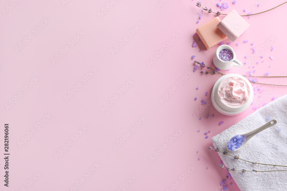 Natural cosmetics with towel and lavender on color background