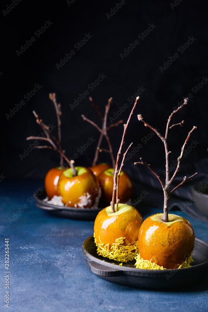 Tasty candy apples on dark table