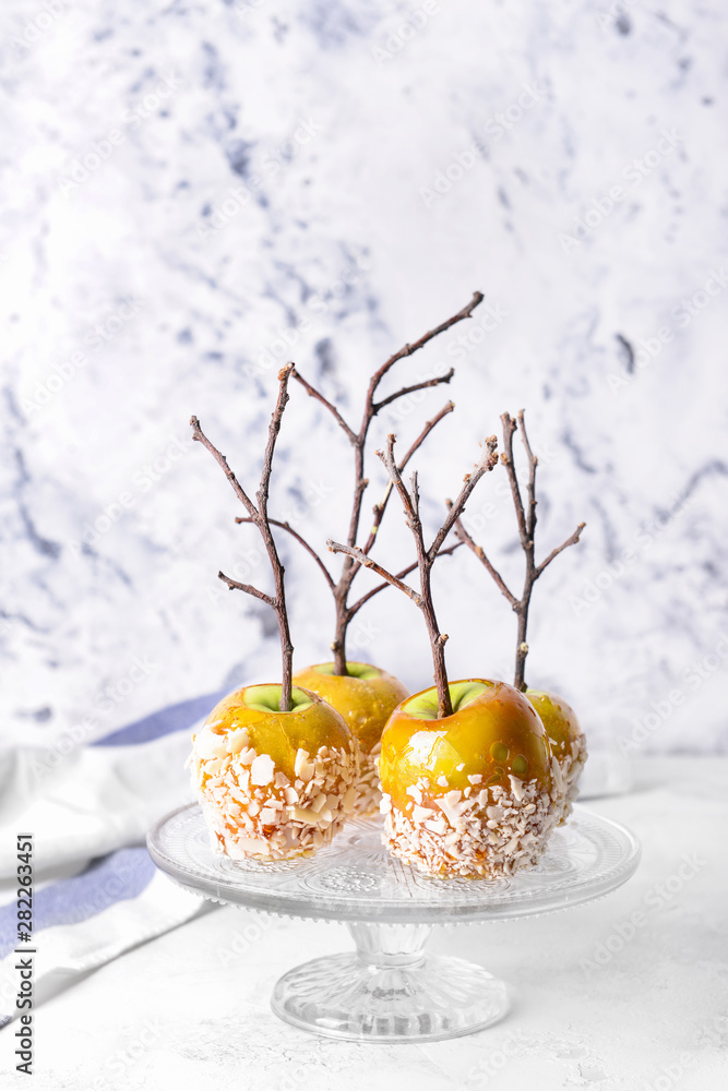 Dessert stand with tasty candy apples on table