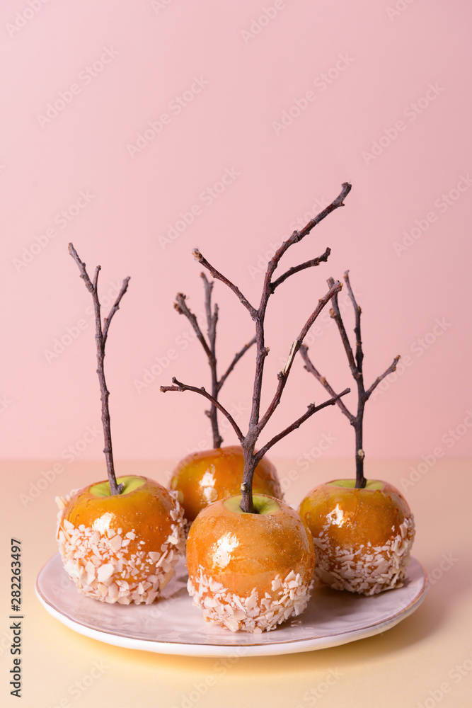 Plate with tasty candy apples on table