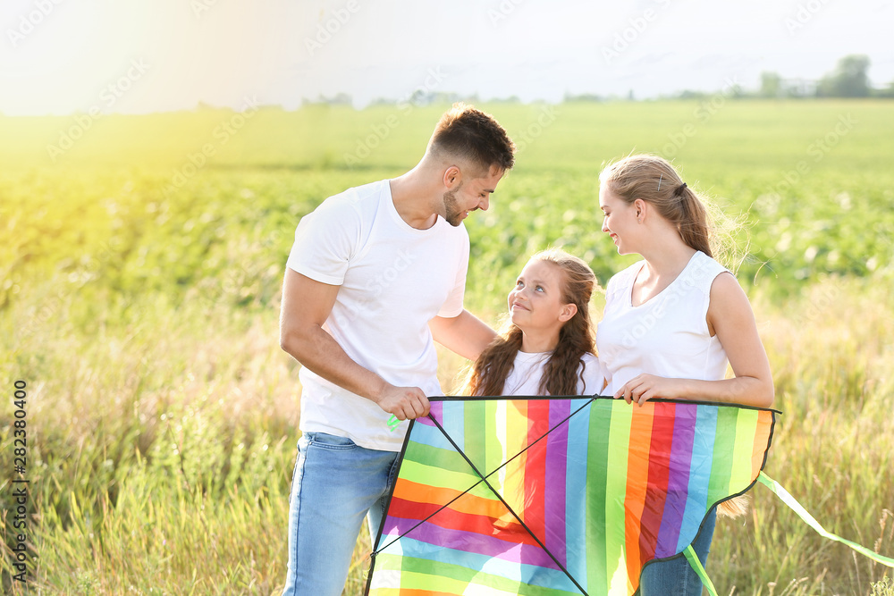 Happy family with kite in field