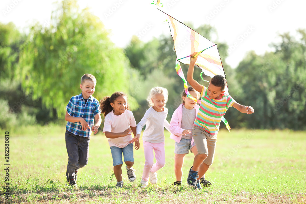 Group of happy children with kite in park